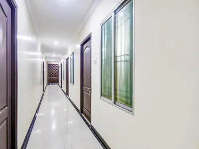 a corridor in a building with windows and a hallway at HOTEL ROYAL PARADISE in Coimbatore