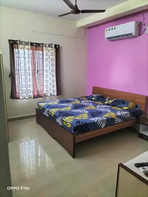 a bedroom with a bed and a purple wall at HOTEL ROYAL PARADISE in Coimbatore