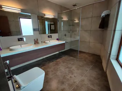 a bathroom with two sinks and a shower and a toilet at Florida Airport Hotel Kochi in Nedumbassery