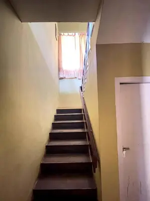 a staircase in a room with a window and a stair case at Rustic 3-BR Villa w/ Front & Back Yards in the mountains in Ooty