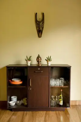a wooden cabinet with dishes and a bottle of wine at Biosphere in Coonoor