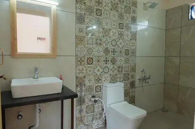 a bathroom with a toilet and a sink and a shower at Biosphere in Coonoor