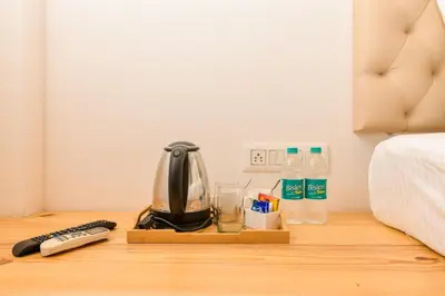 a coffee maker on a table next to a bed at Shine Residency in Mysore