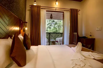 a bedroom with a large white bed with a window at Stephen's Legacy in Vattavada