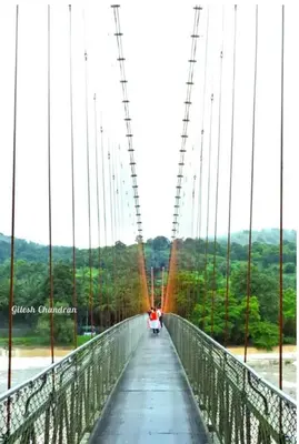 a person riding a motorcycle on a suspension bridge at RAIN DROPS PREMIUM VILLAS - Athirappilly in Athirappilly