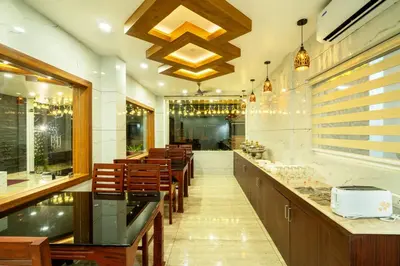a restaurant with a bar with chairs and lights at Daan Regency in Trichūr