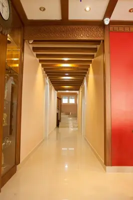 a hallway in a building with a clock on the wall at Srivar Hotels in Guruvāyūr