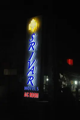 a sign for a hotel are room at night at Srivar Hotels in Guruvāyūr