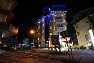 a white building with blue lights on it at night at Srivar Hotels in Guruvāyūr