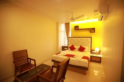 a bedroom with a bed and a table and a chair at Sree Bharat Residency in Alāndurai