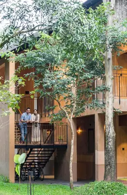 two people standing on a balcony of a building at Klov Resort & Spa in Wayanad