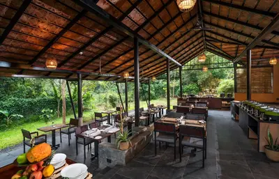a dining room with tables and chairs at Klov Resort & Spa in Wayanad