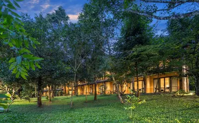 a building with trees in front of it at Klov Resort & Spa in Wayanad