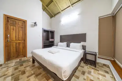 a bedroom with a large white bed in a room at Tranqville Resorts in Ooty