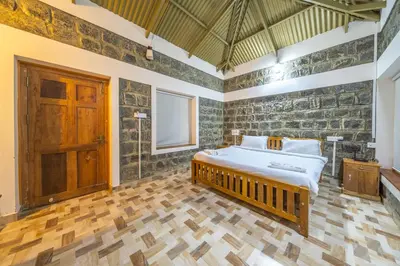 a bedroom with a bed and a wooden floor at Tranqville Resorts in Ooty