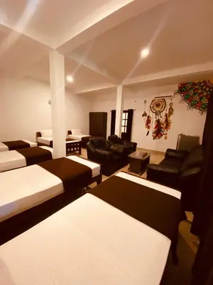 a room with couches and chairs and a living room at 3 Hills Hostel in Wayanad