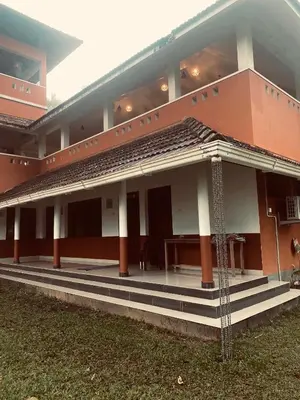a building with steps and a table in front of it at 3 Hills Hostel in Wayanad