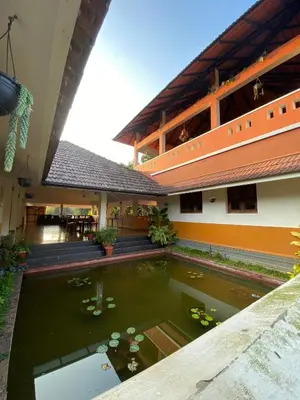 a koi pond in the courtyard of a building at 3 Hills Hostel in Wayanad