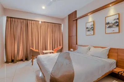 a hotel room with a large bed and a window at Samasth Palatial in Mysore