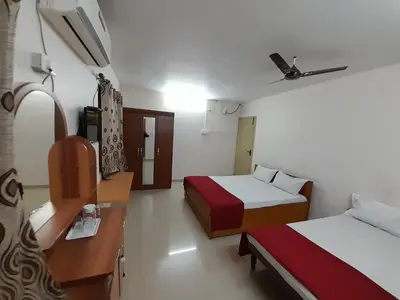 a hotel room with two beds and a desk at SUPREME RESIDENCY in Coimbatore