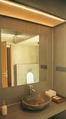 a bathroom with a sink with a large mirror at Fireflies Kabini in Begūr