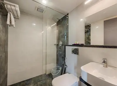 a bathroom with a toilet and a sink and a shower at Hotel Vijay Fablis in Coimbatore
