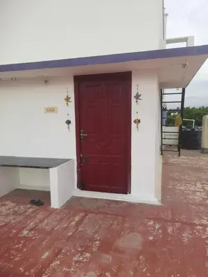 a red door on the side of a building at WHITE HOUSE- 1BK Pleasant Apartment with Open Terrace in Coimbatore