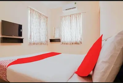 a bedroom with a bed with red pillows and a tv at HOTEL LEMONADE in Coimbatore