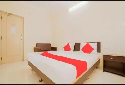 a bedroom with a large white bed with red pillows at HOTEL LEMONADE in Coimbatore