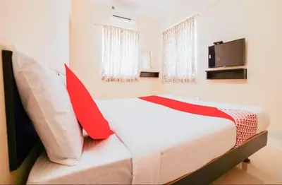 a bedroom with a bed with red pillows and a tv at HOTEL LEMONADE in Coimbatore