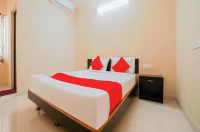 a bedroom with a large white bed with red pillows at HOTEL LEMONADE in Coimbatore