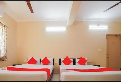 two beds in a room with red pillows at HOTEL LEMONADE in Coimbatore