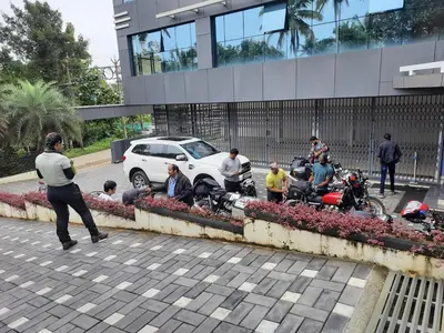 a group of people sitting on a curb in front of a building at Emerald Royal Residency in Cochin