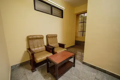 a waiting room with two chairs and a table at Hotel oneiro in Trichūr