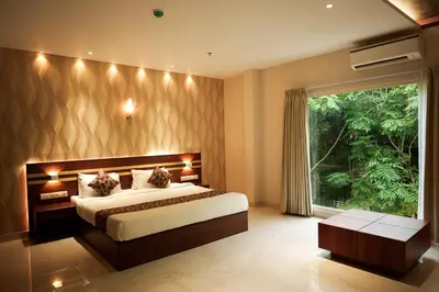 a bedroom with a large bed and a large window at Valluvanad Residency in Perintalmanna