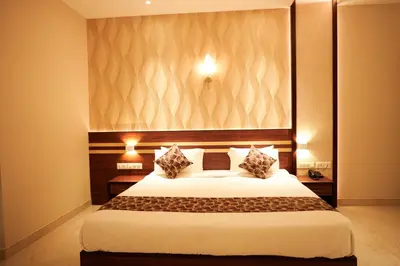 a bedroom with a large white bed with two pillows at Valluvanad Residency in Perintalmanna