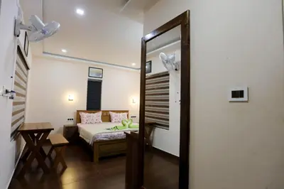 a bedroom with a bed and a table and a mirror at Agronest Farm by LivingStone in Sultan Bathery