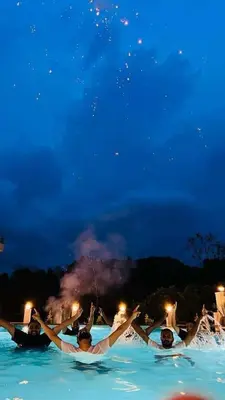 a group of people in the water at night at Besrauma Vythiri in Vythiri