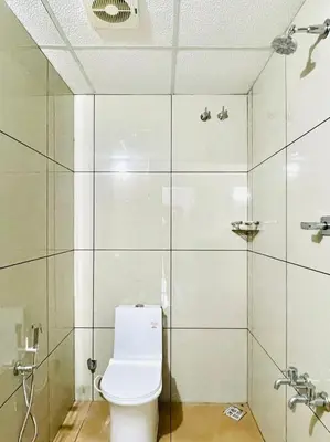 a bathroom with a toilet and a shower at Zam Zam Residency in Cheruppulasseri
