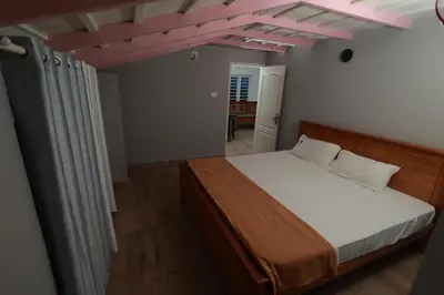 a bedroom with a bed and a pink ceiling at Babu's Homestay By Lexstays in Mananthavady