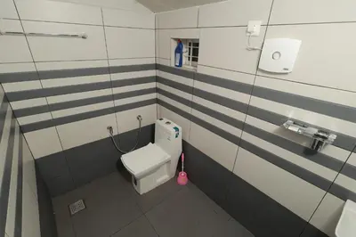 a small bathroom with a toilet and a sink at Babu's Homestay By Lexstays in Mananthavady