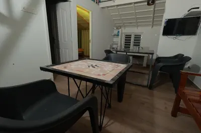 a living room with a table and chairs and a television at Babu's Homestay By Lexstays in Mananthavady