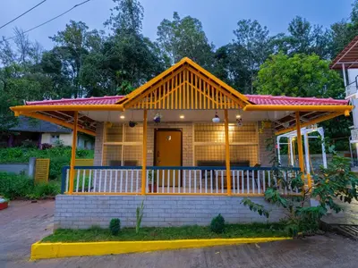 a yellow house with a red roof at The Hosteller Coorg, Madikeri in Madikeri