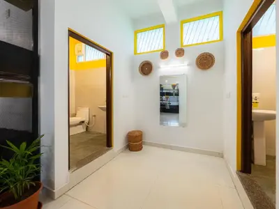 a hallway with a bathroom with a mirror and a sink at The Hosteller Coorg, Madikeri in Madikeri