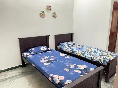two beds sitting next to each other in a bedroom at WHITE HOUSE - 3BHK Elite Apartment in Coimbatore