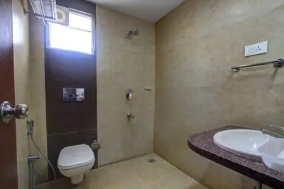 a bathroom with a toilet and a sink at Hotel Prince Gardens in Coimbatore