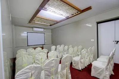 a room with a bunch of chairs and a screen at Hotel Prince Gardens in Coimbatore
