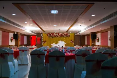 a banquet hall with red and white tables and chairs at Hotel Prince Gardens in Coimbatore
