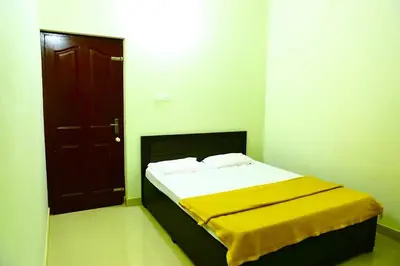 a bedroom with a bed with a yellow blanket on it at Shibi's Tea Garden Heritage in Vayittiri