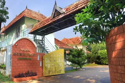 a building with a yellow door and a brick wall at Vajra Ayurveda and Yoga Retreat in Cochin